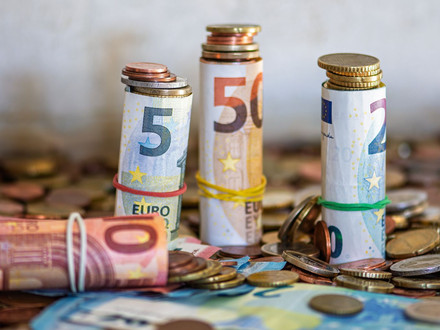 Das Bild zeigt viele Euro-Geldscheine und Münzen als thematisches Bild zum Thema Haushalt.