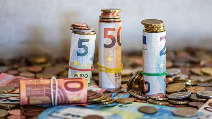 Das Bild zeigt viele Euro-Geldscheine und Münzen als thematisches Bild zum Thema Haushalt.