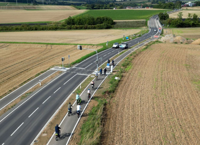 Drohnenaufnahme des neuen Radwegs während der Befahrung durch die Gruppe.