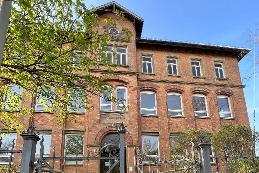 Man sieht die Alte Staufenbergschule von vorne mit Eingangstor