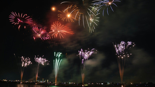 Das Bild zeigt einen Nachthimmel mit sprühenden Silvesterfontänen. 