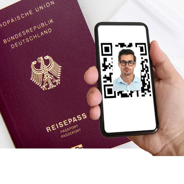 Ein Reisepass und jemand der ein Handy mit einem QR-Code und einem Passfoto darin hält