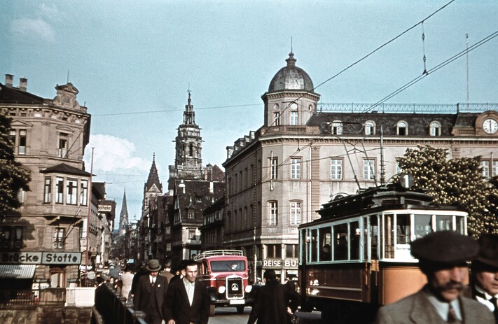 Das Bild zeigt  das Areal von der Ebert-Brücke Richtung Kaiserstraße mit der Heilbronner Altstadt vor dem schweren Bombenangriff 1944. Ins Auge techen das Alte Hauptpostamt (rechts), die Kilianskirche und die kleine Straßenbahn.
