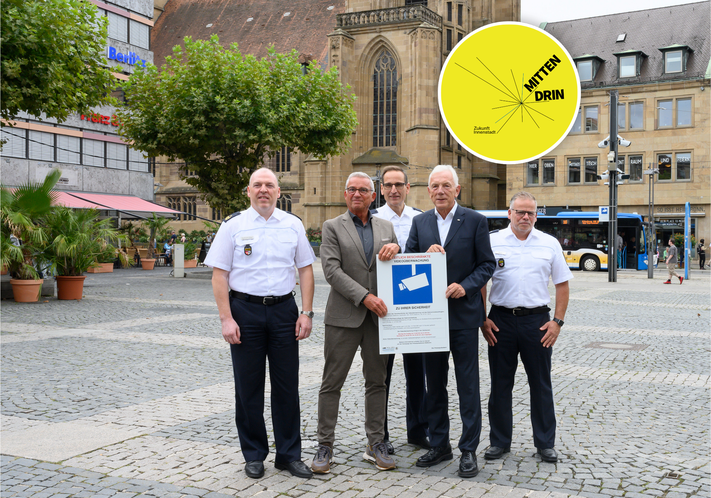 Start für die Videoüberwachung auf dem Heilbronner Marktplatz: (v.l.) Polizeipräsident Frank Spitzmüller, Innenminister Thomas Strobl, stv. Polizeipräsident Markus Geistler, Oberbürgermeister Harry Mergel und Polizeipressesprecher Frank Belz präsentieren ein Hinweisschild mit Informationen zur Videoüberwachung. Sieben davon sind rund um den Marktplatz für alle gut sichtbar angebracht. Foto: Stadtarchiv / Barbara Kimmerle