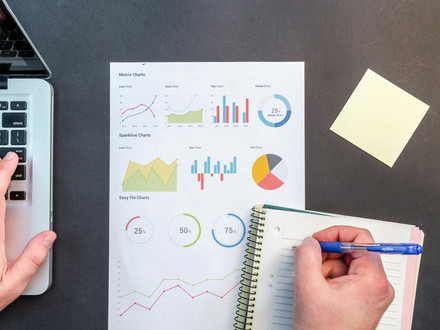 Das Themenbild zur Mikrozensus-Umfrage zeigt eine Tischplatte mit Block, Stift, Taschenrechner und einem Blatt Papier mit verschiedenen Grafiken. 