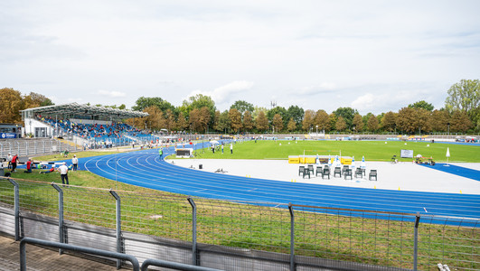 Das Bild zeigt das Frankenstadion in Heilbronn mit der blauen Laufbahn, dem Fußballrasen und der Tribüne. 