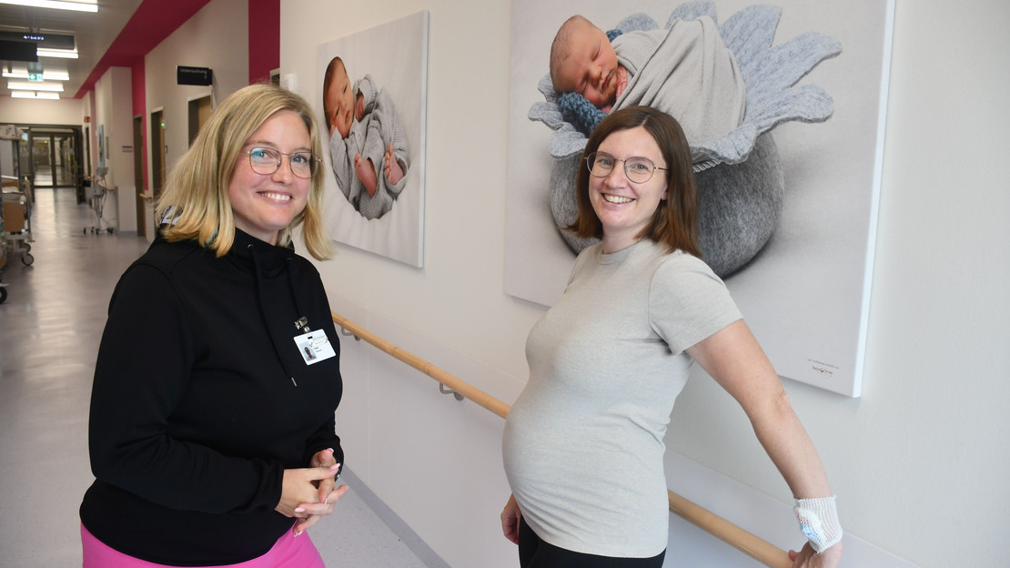Auf dem Bild sind die Kliniklotsin und eine hochschwangere Frau auf dem Flur der SLK-Geburtenstation zu sehen.