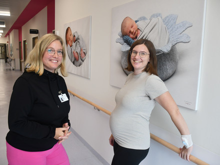 Auf dem Bild sind die Kliniklotsin und eine hochschwangere Frau auf dem Flur der SLK-Geburtenstation zu sehen.