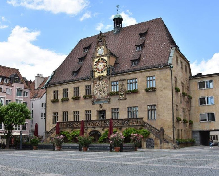 Das Bild zeigt das Heilbronner Rathaus mit der Freitreppe und der astronomischen Uhr vom Marktplatz aus. 