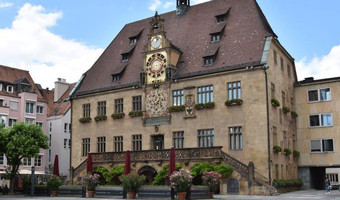 Das Bild zeigt das Heilbronner Rathaus mit der Freitreppe und der astronomischen Uhr vom Marktplatz aus. 