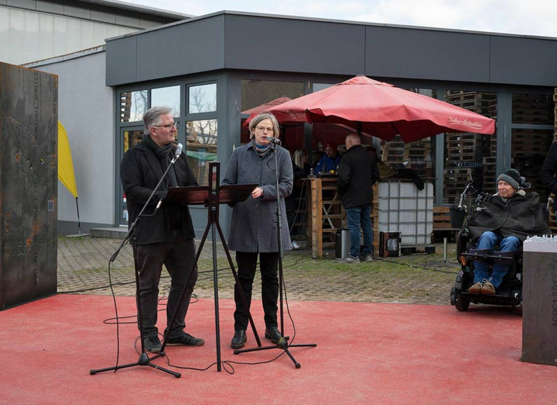 Grünflächenamtsleiter Oliver Toellner und Archivleiterin Miriam Eberlein erläutern vor rund 150 Interessierten das neue Gedenkkonzept, das das ehemalige KZ "Steinbock" mit dem KZ-Friedhof verbindet. Rechts im Bild: das Modell des Arbeitslagers.