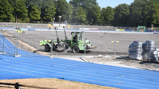 Das Bild zeigt Baumaschinen im Einsatz auf dem geschotterten Untergrund des Spielfeldes im Frankenstadion. Vorarbeiten für den Einbau einer Rasenheizung sind im Gange. 