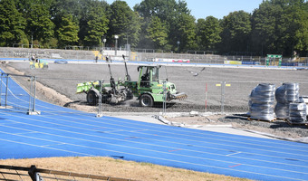 Das Bild zeigt Baumaschinen im Einsatz auf dem geschotterten Untergrund des Spielfeldes im Frankenstadion. Vorarbeiten für den Einbau einer Rasenheizung sind im Gange.