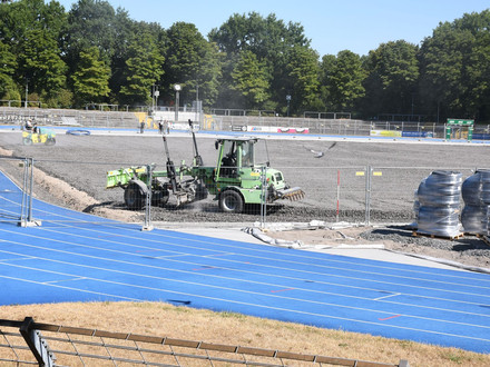Das Bild zeigt Baumaschinen im Einsatz auf dem geschotterten Untergrund des Spielfeldes im Frankenstadion. Vorarbeiten für den Einbau einer Rasenheizung sind im Gange. 