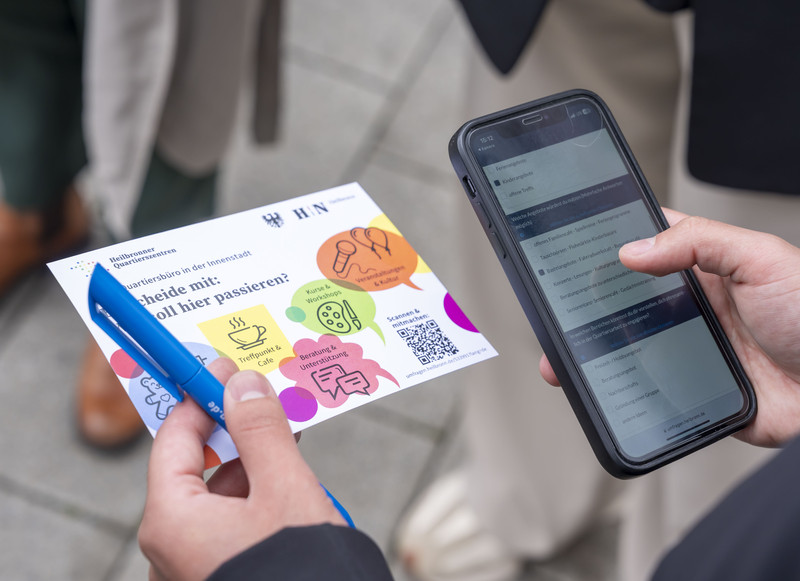 Das Bild zeigt eine Postkarte mit Fragen und QR-Code zur Umfrage zum neuen Quartiersbüro.