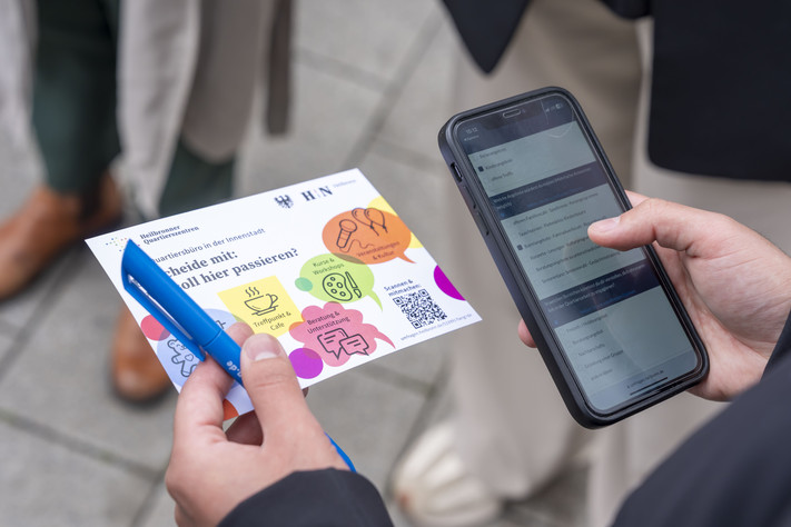 Das Bild zeigt eine Postkarte mit Fragen und QR-Code zur Umfrage zum neuen Quartiersbüro.