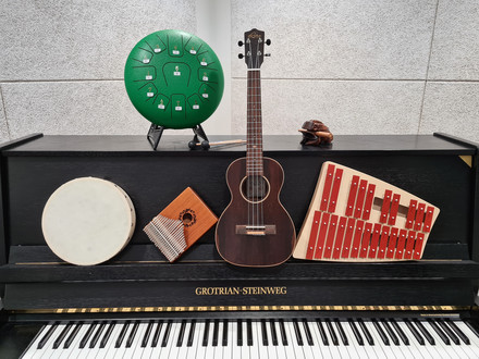 Das Bild zeigt Musikintstrumente der Stadtbibliothek, die auf einem Klavier abgelegt sind. 