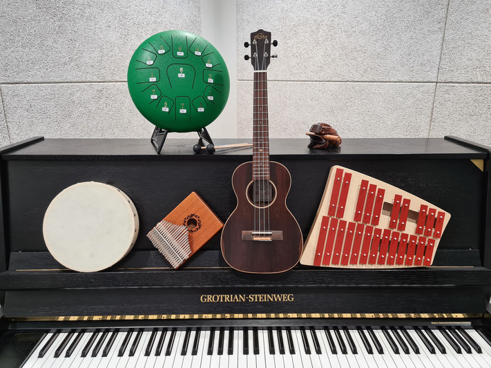 Das Bild zeigt Musikintstrumente der Stadtbibliothek, die auf einem Klavier abgelegt sind. 