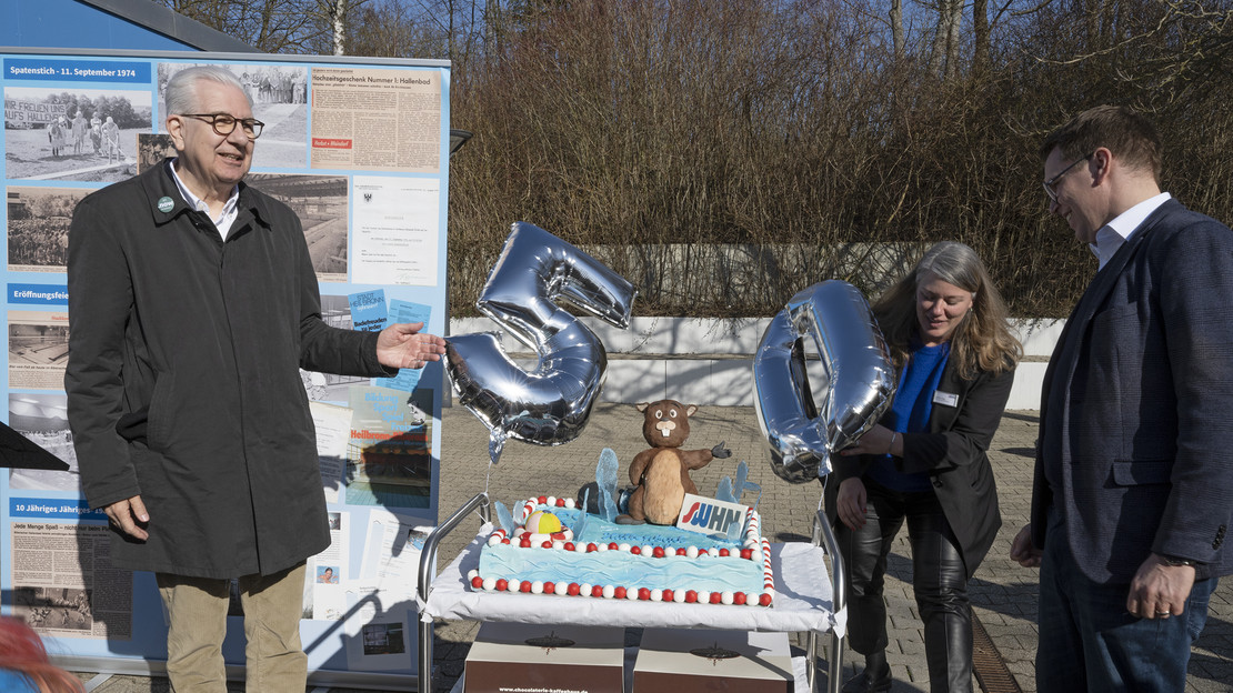 Das Bild zeigt Bürgermeister Martin Diepgen und die Stadtwerke-Vertrteter Erik Mai und Jasmin Lang mit einer Torte samt Biber-Figur zum 50. Geburtstag des Biberacher Hallenbades. 