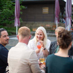 Eine Gruppe Menschen sitzt gemütlich zusammen und trinkt Wein