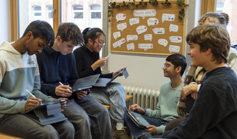 Das Bild zeigt Schülerinnen und Schüler des Robert-Mayer-Gymnasiums in einem Klassenraum, die ihre neuen Tablets ausprobieren.
