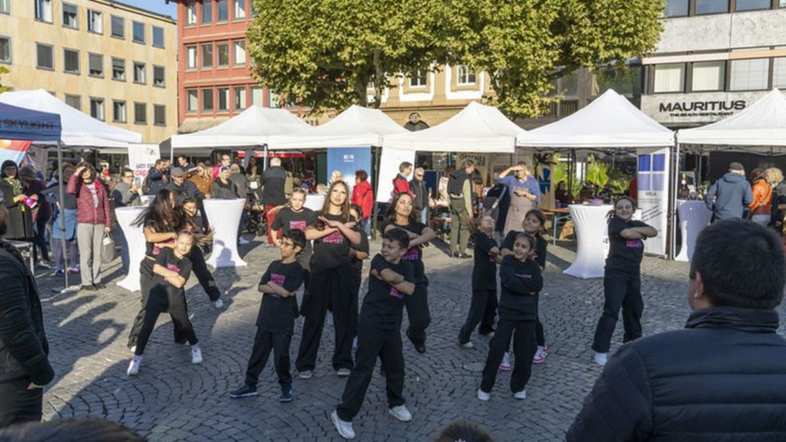 Das Bild zeigt eine Gruppe Schülerinnen und Schüler bei einer Tanzvorführung auf dem Marktplatz. 