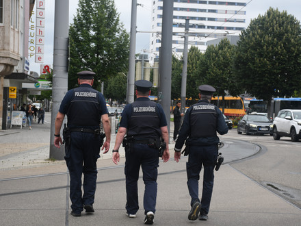 Man sieht drei Mitarbeiter des Kommunalen Ordnungsdienstes der Stadt Heilbronn auf Streife an der Allee.