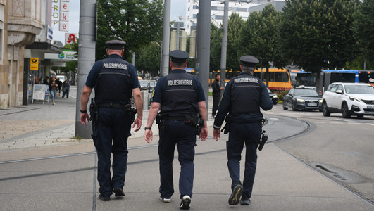 Man sieht drei Mitarbeiter des Kommunalen Ordnungsdienstes der Stadt Heilbronn auf Streife an der Allee.