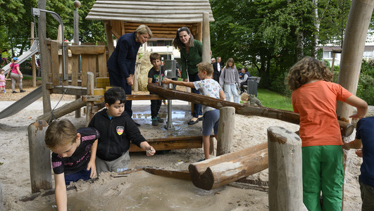 Bürgermeisterin Agnes Christner und Cornelia Lutz, Abteilungsleistung für Planung und Neubau im Grünflächenamt, beim Spielen an der Wasserstation. Foto: Stadtarchiv Heilbronn/B. Kimmerle
