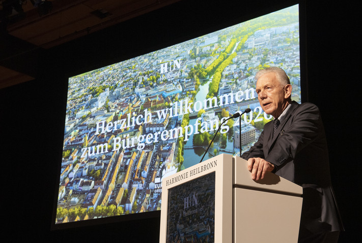 Das Bild zeigt OB Harry Mergel bei seinem Vortrag auf der Bühne der Harmnonie.