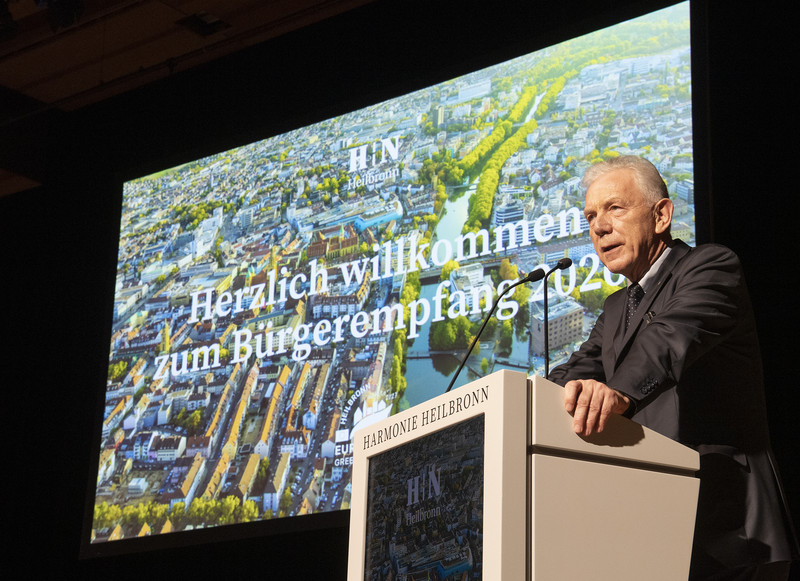 Das Bild zeigt OB Harry Mergel bei seinem Vortrag auf der Bühne der Harmnonie.