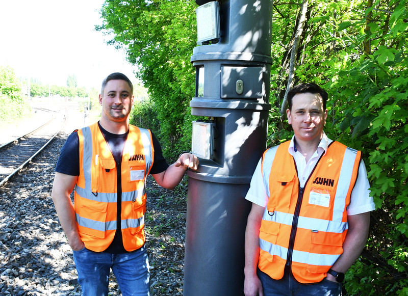Das Bild zeigt zwei Mitarbeiter der Stadtwerke Heilbronn der Waggonerfassungsanlage, eine technische Säule, die per Kamere und Blitz jeden Waggon registirert.
