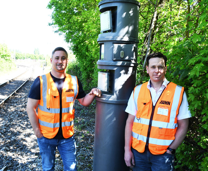 Das Bild zeigt zwei Mitarbeiter der Stadtwerke Heilbronn der Waggonerfassungsanlage, eine technische Säule, die per Kamere und Blitz jeden Waggon registirert.