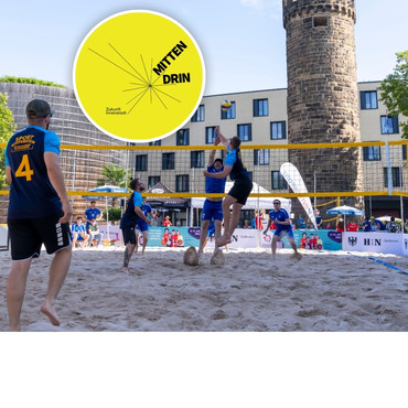 Gruppe spielt Beachvolleyball vor dem Bollwerksturm
