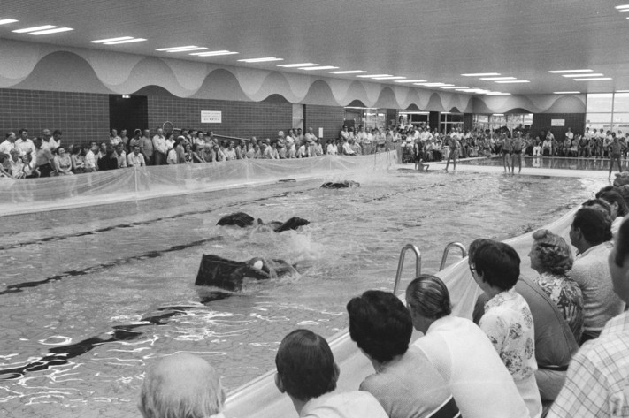 Das Schwarz-Weiß-Bild zeigt dichte Besucherreihen am Beckenrand des neuen Hallenbades in Bibrach. Im Sommer 1976 wurde es mit einem Festprogramm eröffnet.