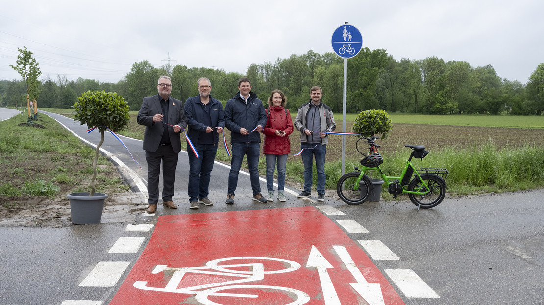 Das Bild zeigt den Startpunkt des neuen Radweges bei Biberach. Bürgermeister Andreas Ringle und weitere Projektebeteiligte schneiden das Band durch und geben den Radweg frei. 