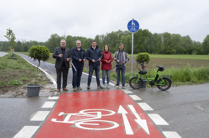 Das Bild zeigt den Startpunkt des neuen Radweges bei Biberach. Bürgermeister Andreas Ringle und weitere Projektebeteiligte schneiden das Band durch und geben den Radweg frei.