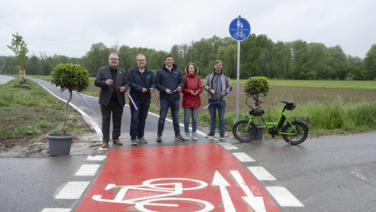 Das Bild zeigt den Startpunkt des neuen Radweges bei Biberach. Bürgermeister Andreas Ringle und weitere Projektebeteiligte schneiden das Band durch und geben den Radweg frei. 