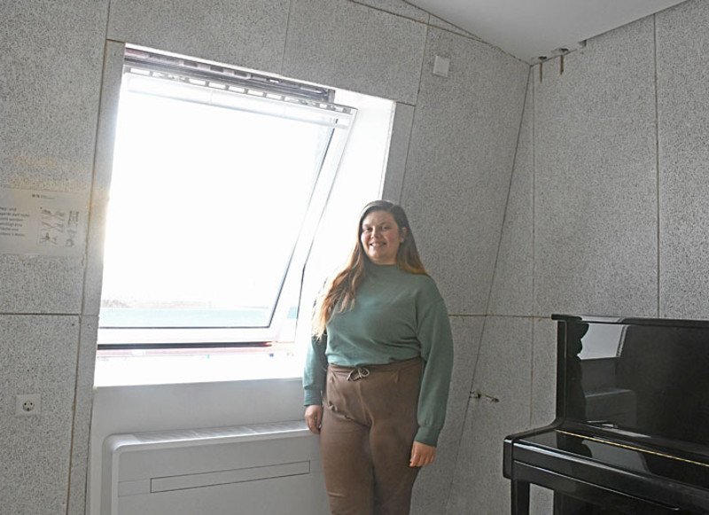 Projektleiterin Christine Ringler vom Gebäudemanagement vor einem der erneuerten Dachfenster und einem der Klimaheizgeräte.