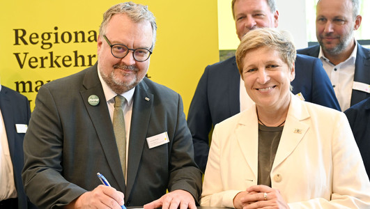Das Bild zeigt Heilbronns Bürgermeister Andreas Ringle mit Landesverkehrsministerin Nicole Razavi beim Unterzeichnen der Vereinbarung.  