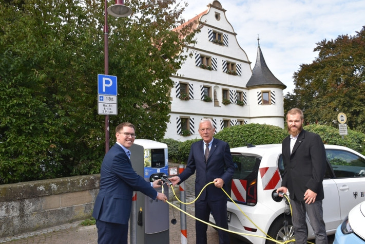 Erik Mai, Geschäftsführer der Stadtwerke Heilbronn, Oberbürgermeister Harry Mergel und Jens Boysen, stellvertretender Leiter des Amts für Straßenwesen nehmen die E-Ladestation vor dem Bürgeramt Kirchhausen in Betrieb.