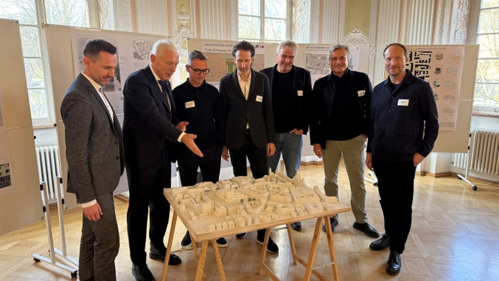 Ideen für die Innenstadt: Wirtschaftsförderer Stefan Ernesti, Oberbürgermeister Harry Mergel sowie die Vertreter der fünf teilnehmenden Architekturbüros sprechen am Stadtmodell Innenstadt über die Ergebnisse. © Stadt Heilbronn
