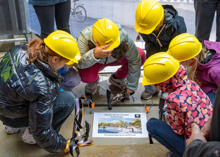 Schülerinnen der Grundschule Alt-Böckingen klopfen die Bodenplatte fest.  
