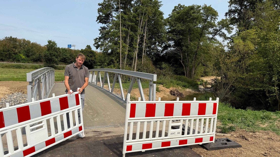 Thomas Feiert, Leiter des Amts für Straßenwesen, gibt die neue Fahrrad- und Fußgängerbrücke über den Böllinger Bach frei. Foto: Milva-Katharina Klöppel