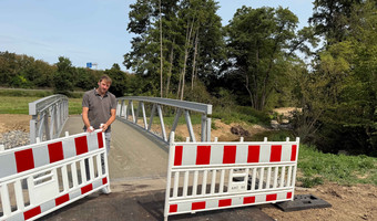 Thomas Feiert, Leiter des Amts für Straßenwesen, gibt die neue Fahrrad- und Fußgängerbrücke über den Böllinger Bach frei. Foto: Milva-Katharina Klöppel