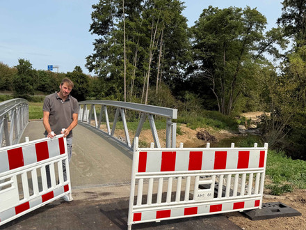 Thomas Feiert, Leiter des Amts für Straßenwesen, gibt die neue Fahrrad- und Fußgängerbrücke über den Böllinger Bach frei. Foto: Milva-Katharina Klöppel
