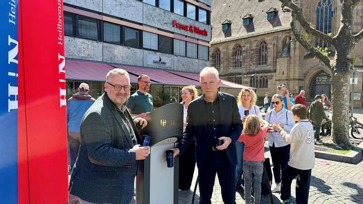 Bei frühlingshaften Temperaturen nahm Oberbürgermeister Harry Mergel (r.) zusammen mit Bürgermeister Andreas Ringle (l.) und Mitgliedern des Gemeinderats den Trinkbrunnen auf dem Marktplatz in Betrieb. Foto: Stadt Heilbronn
