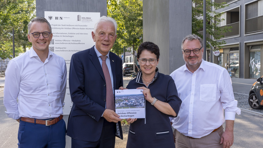 Das Bild zeigt die Übergabe der Holzbau-Broschüre zum Neckarbogen an Ministerin Marion Gentges. Mit dabei (v. li.): Stadtsiedlung-Geschäftsführer Dominik Buchta, Oberbürgermeister Harry Mergel, Baubürgermeister Andreas Ringle. 