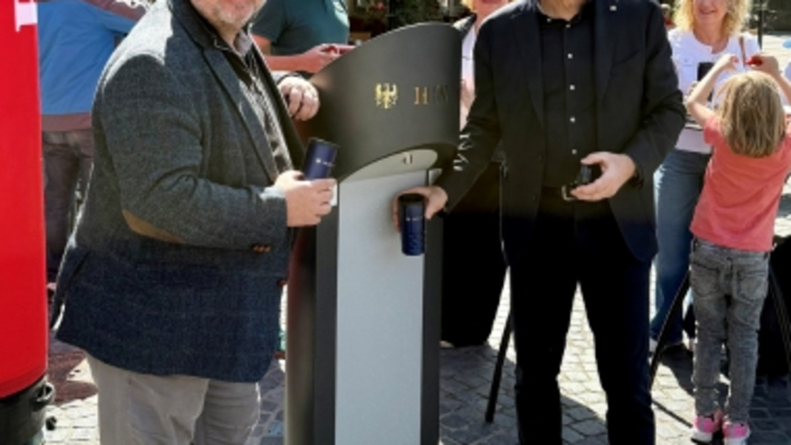 Oberbürgermeister Harry Mergel (r.)und Bürgermeister Andreas Ringle erfrischen sich bei der Einweihung des Trinkbrunnens selbst mit einem Schluck Wasser.