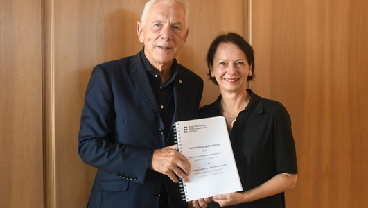 Auf dem Bild zeigen Oberbürgermeister Harry Mergel und Regierungspräsidentin Susanne Bay den Planfeststellungsbeschluss für das wichtige Verkehrsprojekt Nordumfahrung. 